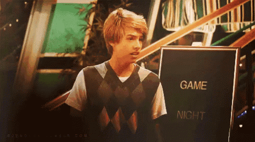 a young man standing in front of a sign that says game night