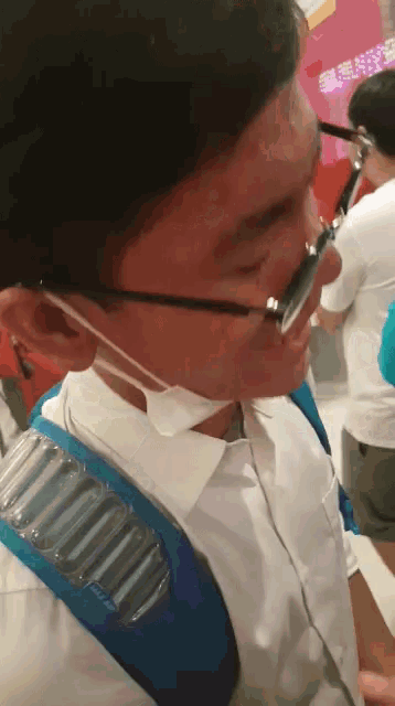 a man wearing glasses and a mask has a backpack on his back