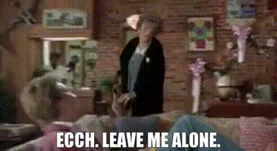 a woman is standing in a living room next to a couch with the words ech leave me alone .