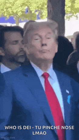 a man in a suit and tie is making a funny face .