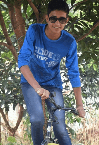 a boy wearing a blue shirt that says ' slide patriot 92 ' on it