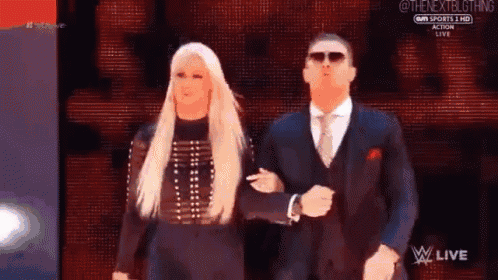 a man in a suit and tie is walking with a woman