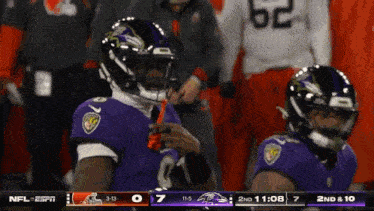 two ravens players are standing on the field during a football game