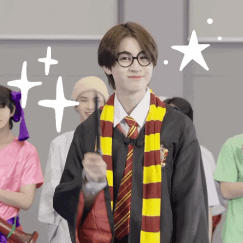 a boy dressed as harry potter holds a wand in his hand