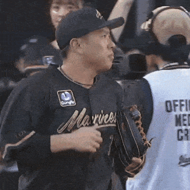 a man wearing a black marines jersey is talking to another man