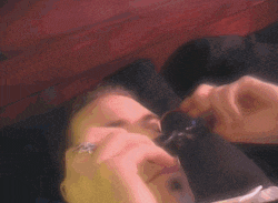 a man laying on a bed looking through a magnifying glass