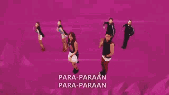 a group of people are dancing in front of a pink background with the words para-paraan para-paraan written on it .