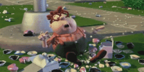 a cartoon character is laying on the ground surrounded by cupcakes .