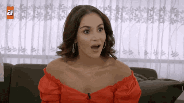 a woman in a red off the shoulder top with the letter a above her
