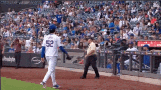 a baseball player with the number 52 on his jersey is walking on the field