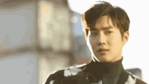 a close up of a man wearing a turtleneck sweater and looking at the camera .