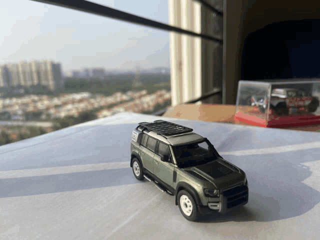 a toy car with a roof rack is sitting on a table in front of a window