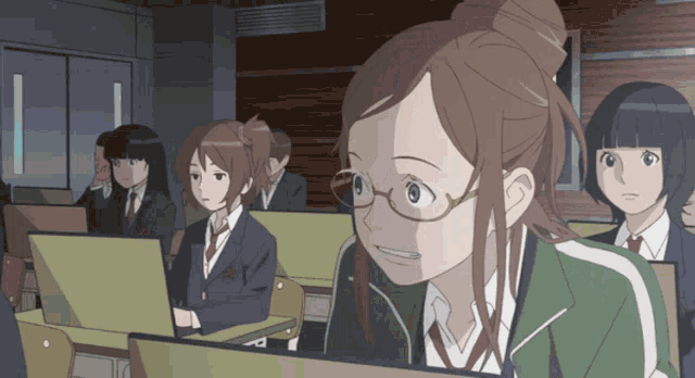 a girl wearing glasses sits in a classroom with other girls