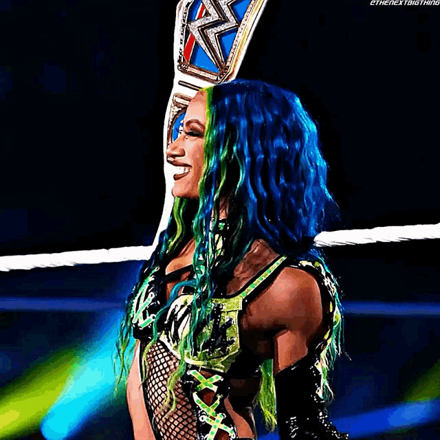 a woman with blue and green hair is holding a wrestling belt .