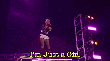 a woman singing on a stage with the words " i 'm just a girl "