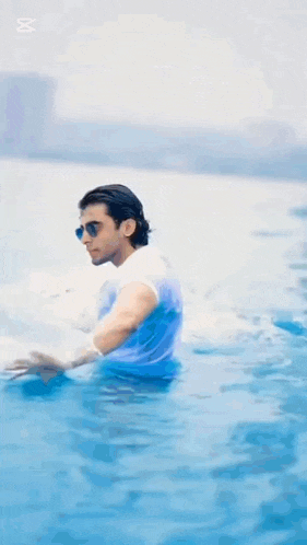 a man in a white shirt and sunglasses is in the water with yaz written on the bottom