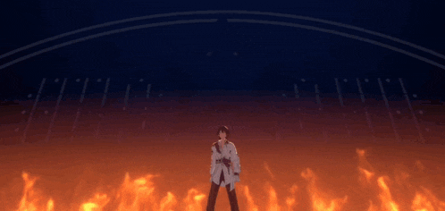 a man in a white shirt is standing in front of a flame