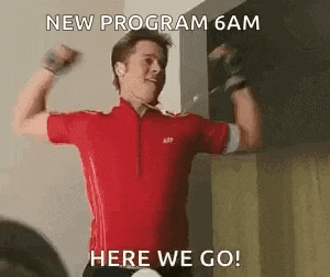 a man in a red shirt is flexing his muscles and says `` new program 6am here we go '' .
