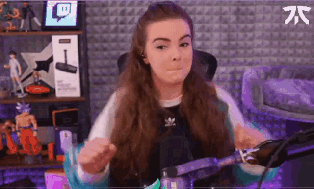 a woman is sitting in front of a microphone holding a knife and making a funny face .