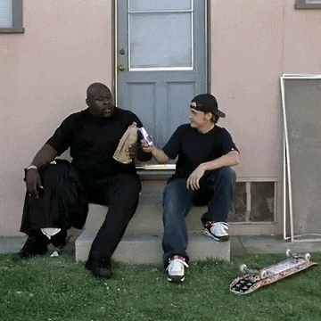 two men are sitting on the steps of a house talking