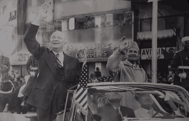 a black and white photo of two men waving in front of a building that says changers
