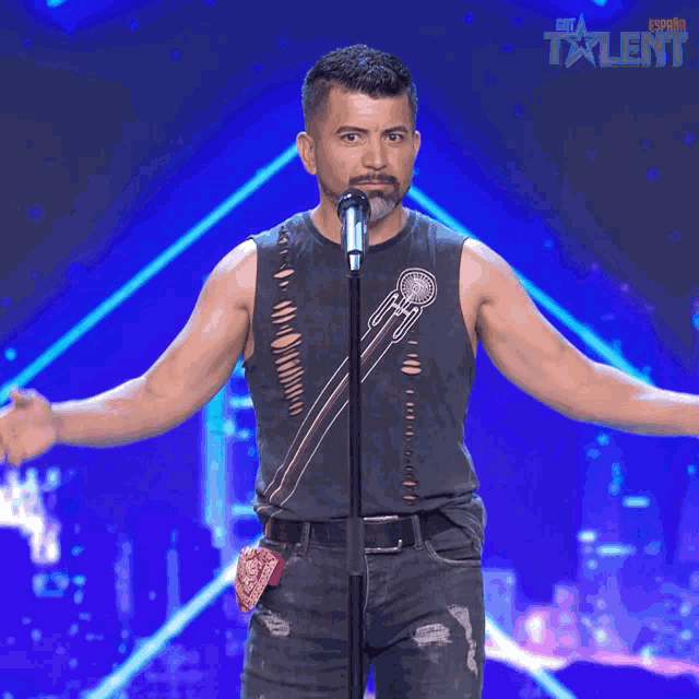 a man is singing into a microphone and the word perfecto is on the screen behind him