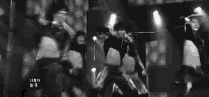 a black and white photo of a group of people dancing on stage .