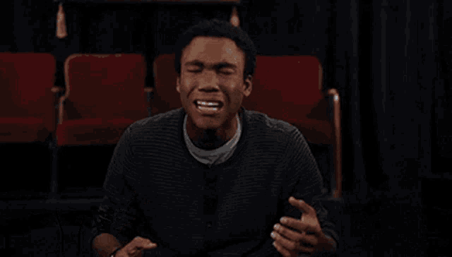 a man sitting in a theater with the words " my emotions " on the bottom