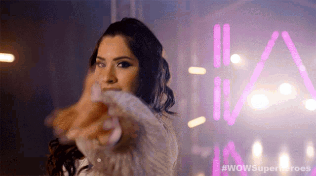 a woman in front of a sign that says wowsuperheroes