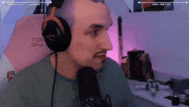a man wearing headphones sits in a chair that says tear baj on it