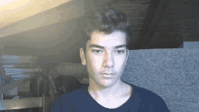 a young man wearing a black shirt looks at the camera
