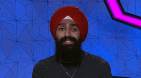 a man in a red turban is making a heart with his hands