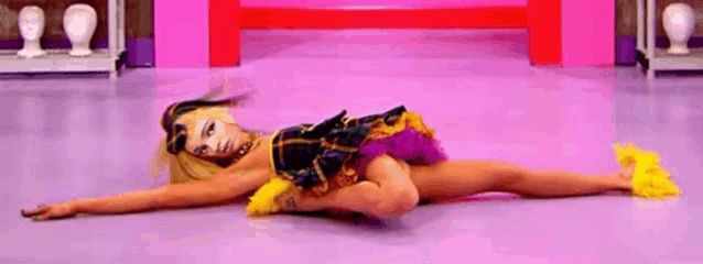 a woman in a costume is laying on the floor with her arms outstretched .