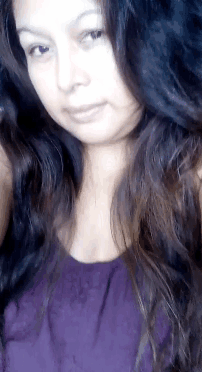 a woman with long hair is wearing a purple shirt
