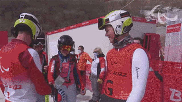 a group of skiers are standing in front of a wall that says 2022