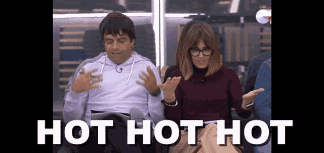 a man and a woman are sitting next to each other and the words hot hot hot are visible