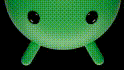 a close up of a green object with black eyes on a black background