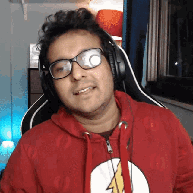 a man wearing glasses and headphones is sitting in a chair