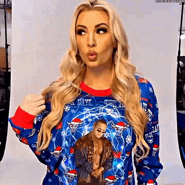 a woman wearing a christmas sweater with a picture of a man on it