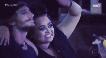 a man and a woman are sitting next to each other and smiling .