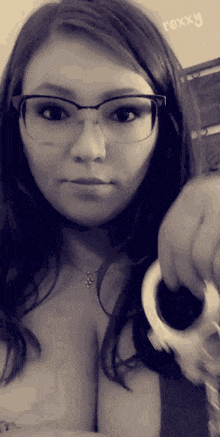 a woman wearing glasses holds a pair of handcuffs