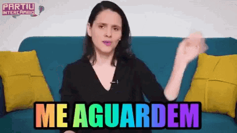 a woman is sitting on a blue couch with the words me aguardem written on it