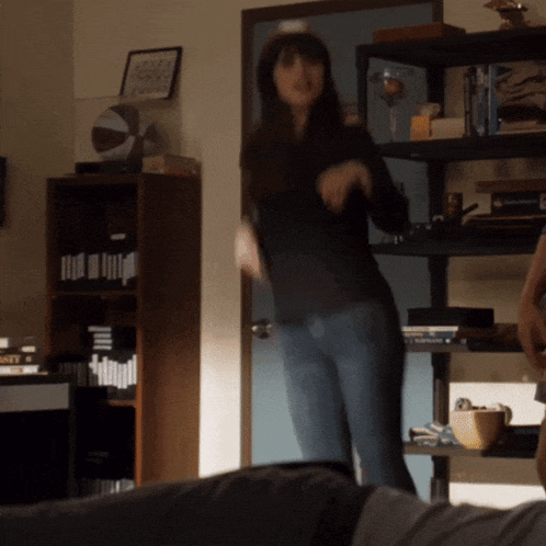 a woman is dancing in a room with a basketball on the shelf