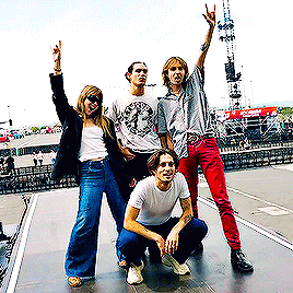 a group of people are posing for a picture and one of them is wearing a shirt with a clock on it