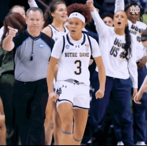 a female basketball player wearing a white jersey that says notre dame