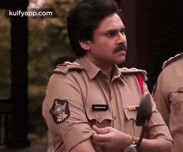 a man in a police uniform with a mustache is holding a stick .