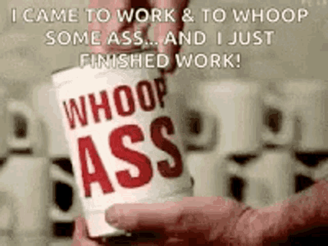 a person is holding a can of whoop ass .