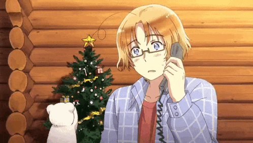 a man talking on a phone with a christmas tree in the background