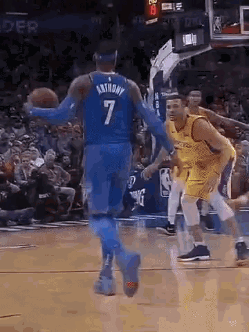 a basketball player with the number 7 on his back is dribbling the ball