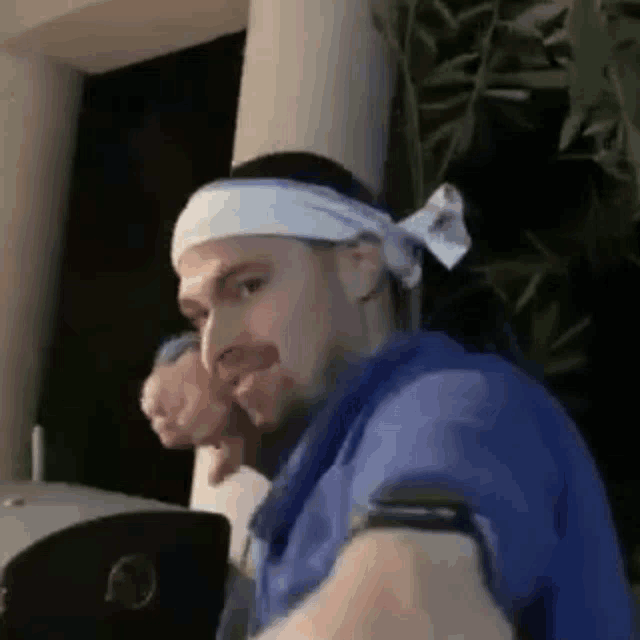 a man wearing a headband is taking a selfie .